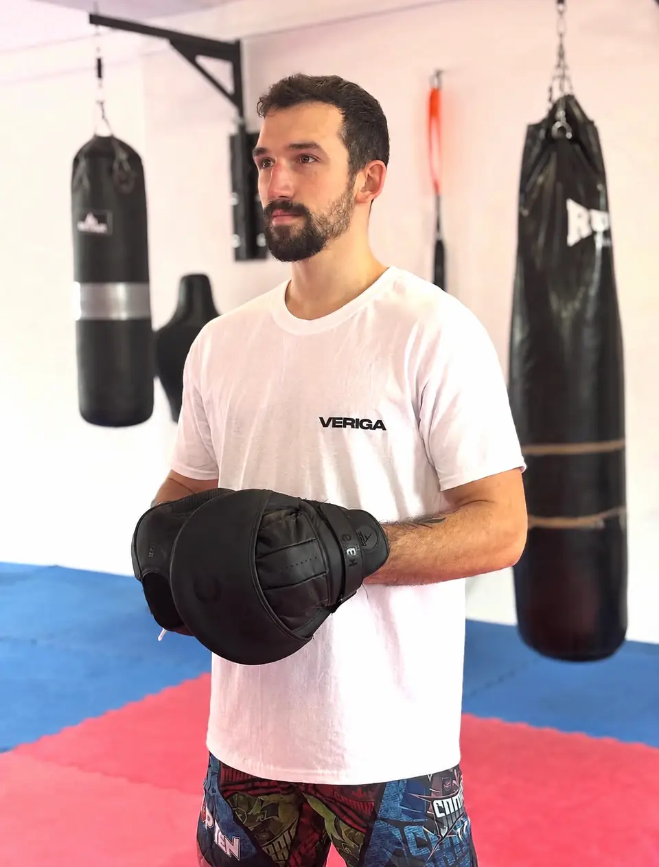 Trener kickboxa Jakob Šimnic z boksarskimi rokavicami ob boksarski vreči