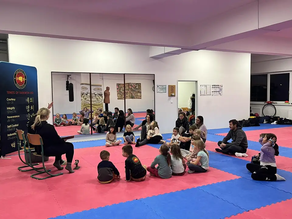 Otroci poslušajo pravljico v dvorani Centra Veriga