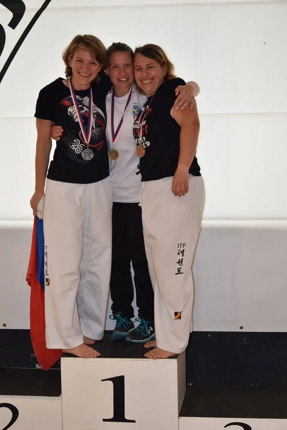 Tri tekmovalke z medaljami na stopničkah